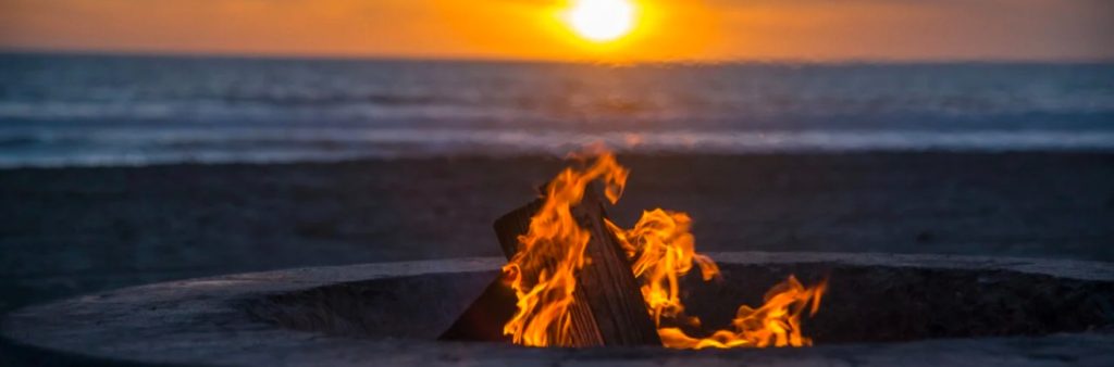 roasting marshmallows on a beach bonfire at sunset